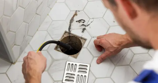 Plumber unclogging a drain